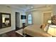 Tranquil bedroom featuring a tray ceiling, wood floors, and a view of the ensuite bathroom at 8135 Nw 26Th Lane Rd, Ocala, FL 34482