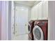 Laundry room with cabinetry and modern red washer and dryer at 8135 Nw 26Th Lane Rd, Ocala, FL 34482