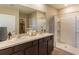 Bright bathroom featuring a double sink vanity, walk-in shower, and linen closet at 8506 Las Palmas Way, Wildwood, FL 34785