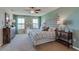 Relaxing bedroom featuring neutral walls, carpet floors, ceiling fan, and a large window with natural light at 8514 Las Palmas Way, Wildwood, FL 34785