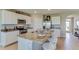 A view of the bright kitchen with an island that features seating, granite countertops and stainless steel appliances at 8514 Las Palmas Way, Wildwood, FL 34785