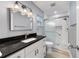 Bathroom featuring a new vanity with a black marble countertop and tiled shower with glass door at 8703 Sw 93Rd Ln # A, Ocala, FL 34481