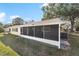 Rear view of home with a screened in porch and gravel bed to deter standing water at 8703 Sw 93Rd Ln # A, Ocala, FL 34481