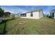 View of backyard featuring grass and the home's exterior with a screened-in lanai at 912 Chula Ct, Lady Lake, FL 32159