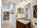 Stylish bathroom featuring a wooden vanity with a granite countertop and a large mirror at 9697 Sw 63Rd Loop, Ocala, FL 34481