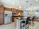 Open concept kitchen and dining area, complete with wooden cabinets, island, seating and stainless appliances at 9697 Sw 63Rd Loop, Ocala, FL 34481