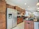 Stainless steel refrigerator in a kitchen with wooden cabinets, a black countertop island and tiled backsplash at 9697 Sw 63Rd Loop, Ocala, FL 34481