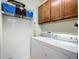 Functional laundry room features a washer, dryer, overhead storage and wood cabinets at 9697 Sw 63Rd Loop, Ocala, FL 34481