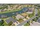 Aerial view of homes surrounding a pond with fountains, showcasing lush landscaping and community layout at 10138 Lake Miona Way, Oxford, FL 34484
