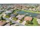 Stunning aerial view of homes surrounding a scenic lake with fountains at 10138 Lake Miona Way, Oxford, FL 34484