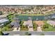 Aerial view of homes surrounding a pond with fountains, showcasing lush landscaping and community layout at 10138 Lake Miona Way, Oxford, FL 34484