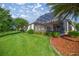 Well-maintained backyard featuring a screened lanai and a view of lush greenery at 10138 Lake Miona Way, Oxford, FL 34484