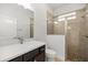 Bright bathroom features a glass shower, with dark vanity and light countertops at 10138 Lake Miona Way, Oxford, FL 34484