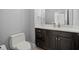 Bathroom with dark cabinets, quartz countertop, modern fixtures, and a neutral paint color at 10138 Lake Miona Way, Oxford, FL 34484