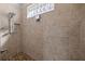Bathroom shower featuring tile surround, a shower niche, and a tiled shower floor at 10138 Lake Miona Way, Oxford, FL 34484