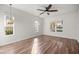 Bright bedroom with wood floors, three windows, and neutral paint at 10138 Lake Miona Way, Oxford, FL 34484
