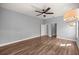 Bedroom with hardwood floors, neutral paint, ceiling fan and chandelier at 10138 Lake Miona Way, Oxford, FL 34484