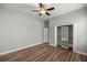 Open bedroom with wood flooring, a ceiling fan, and closet at 10138 Lake Miona Way, Oxford, FL 34484