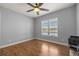 A bright room with wood floors, ceiling fan, and a large window with outdoor views at 10138 Lake Miona Way, Oxford, FL 34484