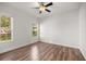 Large bright empty room with wood floors, ceiling fan, and dual windows at 10138 Lake Miona Way, Oxford, FL 34484
