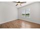 Bright bedroom with wood floors, ceiling fan, and a large window overlooking a pond at 10138 Lake Miona Way, Oxford, FL 34484
