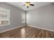 An empty room with wood floors, ceiling fan, and a large window that allows ample light at 10138 Lake Miona Way, Oxford, FL 34484