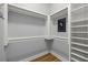 Walk-in closet featuring custom shelving, wood floors, and safe at 10138 Lake Miona Way, Oxford, FL 34484
