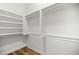 Walk-in closet featuring shelving and laminate wood flooring at 10138 Lake Miona Way, Oxford, FL 34484