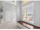 Bright foyer featuring neutral tones, tiled floor, a storage bench, and a large sunlit window at 10138 Lake Miona Way, Oxford, FL 34484