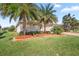 Well-maintained front yard with lush grass, palm trees, and tidy landscaping at 10138 Lake Miona Way, Oxford, FL 34484