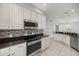 Updated kitchen featuring stainless steel appliances, tile backsplash, and granite countertops at 10138 Lake Miona Way, Oxford, FL 34484