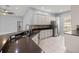 An open kitchen with a stainless steel refrigerator, white cabinets, and granite countertops at 10138 Lake Miona Way, Oxford, FL 34484