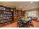 Well-appointed library with bookshelves, a table, and seating, offering a quiet space for reading and studying at 10138 Lake Miona Way, Oxford, FL 34484