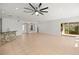 Large living area with tiled floors, a stone-accented bar, and a modern ceiling fan, perfect for entertaining at 10138 Lake Miona Way, Oxford, FL 34484