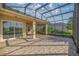 Spacious screened-in patio with beautiful stone flooring, perfect for outdoor entertaining and relaxation at 10138 Lake Miona Way, Oxford, FL 34484