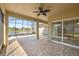 Covered patio area with large screen and tile flooring overlooking pond and water fountain at 10138 Lake Miona Way, Oxford, FL 34484
