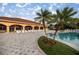 Inviting community pool area featuring comfortable lounge chairs, palm trees, and a well-maintained pool deck at 10138 Lake Miona Way, Oxford, FL 34484