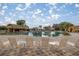 Expansive resort-style pool featuring a rock waterfall and lounge chairs on a paved patio at 10138 Lake Miona Way, Oxford, FL 34484