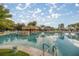 Resort-style pool with a rock waterfall feature and pergola-covered seating area at 10138 Lake Miona Way, Oxford, FL 34484