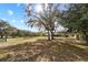 Large backyard with mature shade trees and home in the distance at 10215 Sw 134Th Ct, Dunnellon, FL 34432