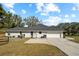 Exterior back view of home featuring a long driveway, back yard, and three car garage at 10215 Sw 134Th Ct, Dunnellon, FL 34432