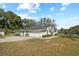 Exterior view of home with a three car garage and well maintained lawn at 10215 Sw 134Th Ct, Dunnellon, FL 34432