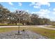 Landscaped yard with mature trees and vintage style lighting at 10215 Sw 134Th Ct, Dunnellon, FL 34432