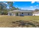 Rear view of the house showing the patio, sliding glass door, and spacious backyard at 10657 Sw 110Th Ct, Dunnellon, FL 34432