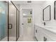 Bathroom featuring a double vanity with black hardware, a glass enclosed shower with blue tile accents and backyard view at 10657 Sw 110Th Ct, Dunnellon, FL 34432