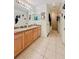 Well-lit bathroom features double sinks, neutral tile, shower and hall access at 13521 N Magnolia Ave, Citra, FL 32113