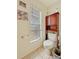 Small bathroom has updated toilet, tiled floor and convenient cabinet storage at 13521 N Magnolia Ave, Citra, FL 32113