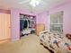 Cozy bedroom features a closet, dresser, and natural light from a window at 13521 N Magnolia Ave, Citra, FL 32113