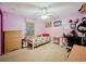 Pink bedroom with a bed, side table, desk, and bright natural light at 13521 N Magnolia Ave, Citra, FL 32113