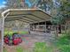 Outdoor carport featuring a metal frame with a lawn mower parked nearby at 13521 N Magnolia Ave, Citra, FL 32113